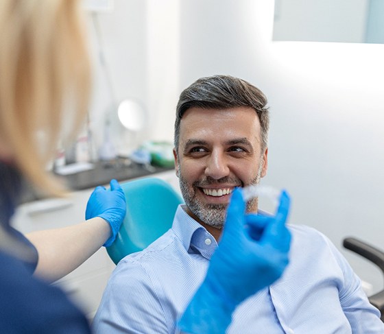 Dentist discussing clear aligners with male adult patient
