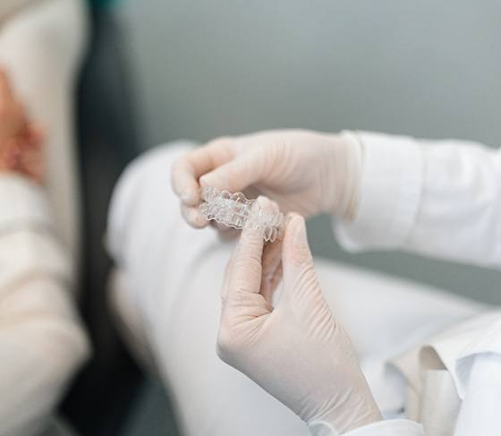 Dentist holding a pair of clear aligners