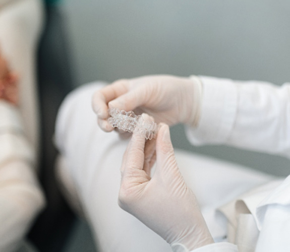 Dentist holding set of clear aligners 