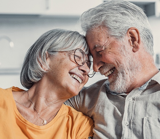 Man without any teeth holding a full denture