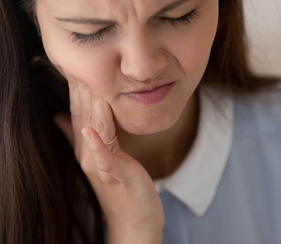 Close up of woman rubbing her jaw in pain