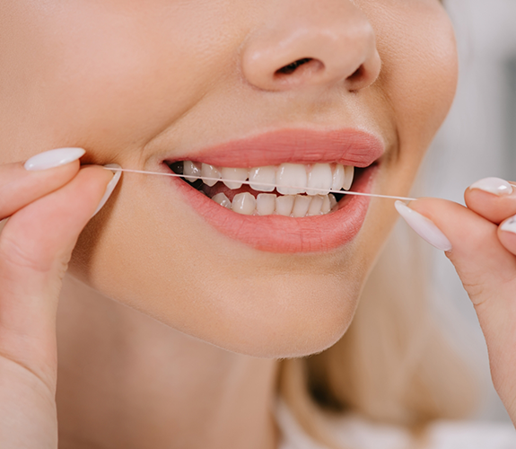 Close up of woman flossing her teeth