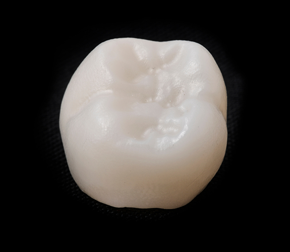Close up of dental crown on black background