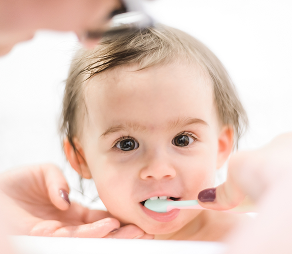 One year old having teeth brushed