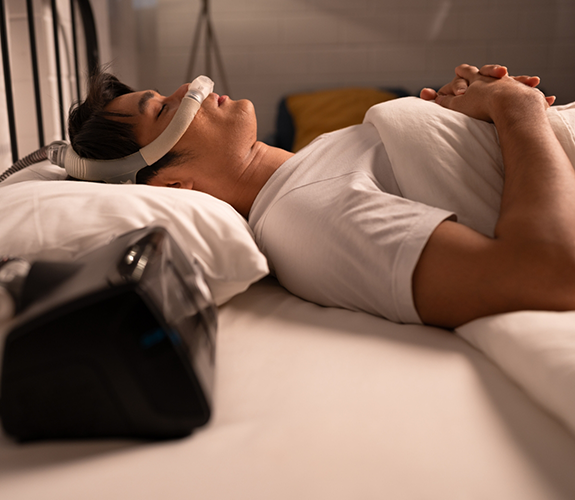 Man lying in bed with CPAP machine