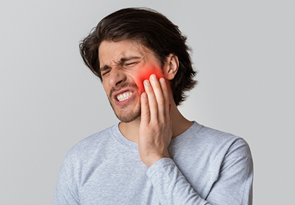 Man holding his cheek in pain