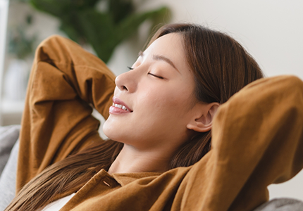 Woman sitting back on couch smiling
